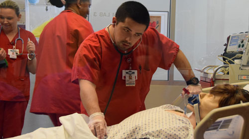 nursing student examining a dummy